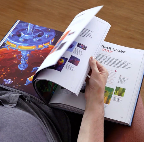 Person flipping through the artbook with a colorful layout.